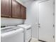 Bright laundry room with washer, dryer, and upper cabinets at 5557 W Buckskin Trl, Phoenix, AZ 85083
