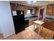 Cozy kitchen features wood cabinets, black appliances, and wood flooring at 9501 E Broadway Rd # 221, Mesa, AZ 85208