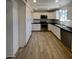 Modern kitchen with white cabinets, stainless steel appliances and wood-look tile floors at 14631 N 36Th Pl, Phoenix, AZ 85032