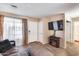 Living room with sofa, electric fireplace, and view into the kitchen at 14300 W Bell Rd # 505, Surprise, AZ 85374