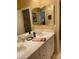 Double vanity bathroom with large mirror and updated fixtures at 10220 E Cochise Dr, Scottsdale, AZ 85258