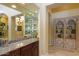 Wet bar with granite countertop, glass shelving, and wooden cabinetry at 10220 E Cochise Dr, Scottsdale, AZ 85258