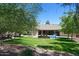 Spacious backyard with a refreshing pool, grassy lawn, and covered patio at 10220 E Cochise Dr, Scottsdale, AZ 85258