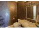 Powder room with decorative wall, granite sink, and ornate mirror at 10220 E Cochise Dr, Scottsdale, AZ 85258