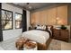 Bright bedroom featuring wood wall accents, a leather bed, and large windows at 24046 N 126Th Pl, Scottsdale, AZ 85255