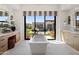 Spa-like bathroom with soaking tub, dual vanities, and sliding glass doors opening to the backyard at 24046 N 126Th Pl, Scottsdale, AZ 85255