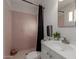 Clean bathroom with pink tile, white vanity, and black shower curtain at 2226 N 61St Ave, Phoenix, AZ 85035