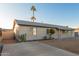 Exterior elevation of a single-story home with a driveway, gravel landscaping, and palm trees at 2226 N 61St Ave, Phoenix, AZ 85035