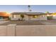 Single-story home with a low wall, gravel landscaping, and palm trees at 2226 N 61St Ave, Phoenix, AZ 85035