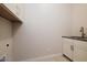 Bright laundry room with white cabinets and a utility sink at 1323 E Eleana Ln, Gilbert, AZ 85298