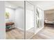 Bright hallway with light wood floors and mirrored closet doors at 8634 E Monterosa Ave, Scottsdale, AZ 85251