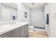 Modern bathroom with gray vanity, marble shower, and light wood floors at 8634 E Monterosa Ave, Scottsdale, AZ 85251