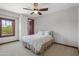 Bedroom with a queen bed, ceiling fan and large window at 13118 N Founders Park Blvd, Surprise, AZ 85379