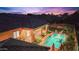 Nighttime aerial view of a home's backyard oasis, showcasing a sparkling pool and patio at 7054 E Ingram St, Mesa, AZ 85207