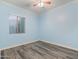 Light blue bedroom with wood-look floors and window at 7054 E Ingram St, Mesa, AZ 85207