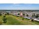Aerial view of home and community, showcasing surrounding golf course and lake at 10802 W Cameo Dr, Sun City, AZ 85351