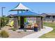 Stone picnic pavilion with BBQ grill and trash can at 4388 W Janie St, San Tan Valley, AZ 85144