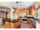 Spacious kitchen with an island, wood cabinets, and granite countertops at 13820 W Cheery Lynn Rd, Avondale, AZ 85392