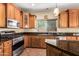 Kitchen boasts wood cabinets, granite counters, and stainless steel appliances at 13820 W Cheery Lynn Rd, Avondale, AZ 85392