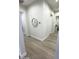Bright hallway with light hardwood floors and a circular mirror at 27222 N 64Th Dr, Phoenix, AZ 85083