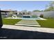 Luxury backyard oasis featuring a rectangular pool, artificial turf, and stone pathways at 27222 N 64Th Dr, Phoenix, AZ 85083