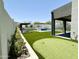 Putting green and patio area beside the pool and outdoor kitchen at 27222 N 64Th Dr, Phoenix, AZ 85083