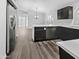 Modern kitchen with dark cabinetry, stainless steel appliances, and luxury vinyl plank flooring at 6447 W Escuda Rd, Glendale, AZ 85308