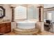 Bathroom with corner soaking tub and decorative columns at 21639 N 55Th Dr, Glendale, AZ 85308