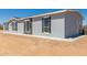 House exterior view, showing light gray siding, windows, and a small backyard at 900 N Windy Meadow Ln, Maricopa, AZ 85139
