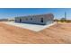 Single story home with gray exterior and a large concrete patio at 900 N Windy Meadow Ln, Maricopa, AZ 85139