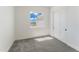 Bright bedroom with large window, grey carpet and double door closet at 3368 W Judd Rd, San Tan Valley, AZ 85144