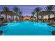 Community pool with relaxing lounge area and palm trees at 16401 W Monterey Way, Goodyear, AZ 85395