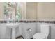 Modern powder room with pedestal sink and decorative tile at 16401 W Monterey Way, Goodyear, AZ 85395