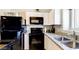 Modern kitchen with white cabinets, black appliances, and granite countertops at 7577 W Darrow St, Laveen, AZ 85339