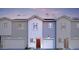 Modern two-story townhome with gray and white exterior, red door, and attached garage at 7577 W Darrow St, Laveen, AZ 85339