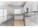 Modern kitchen with granite countertops and white cabinets at 5525 E Dusty Wren Dr, Cave Creek, AZ 85331