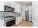 Modern kitchen with stainless steel appliances and white cabinets at 5525 E Dusty Wren Dr, Cave Creek, AZ 85331