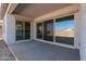 Covered back patio with sliding glass doors leading to the backyard at 21664 E Roundup Way, Queen Creek, AZ 85142