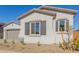 Front yard view of the house with a two-car garage and some plants at 21664 E Roundup Way, Queen Creek, AZ 85142