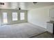 Spacious living room with neutral carpeting and two windows at 137 E Douglas Ave, Coolidge, AZ 85128