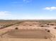 Aerial view of a large property with a riding arena, stables, and paddocks at 48940 W Long Rifle Rd, Aguila, AZ 85320