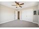 Bedroom with ceiling fan, carpet, and double doors to hallway at 5599 S Alameda Rd, Gold Canyon, AZ 85118