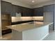 Modern kitchen with dark cabinetry, quartz countertops and breakfast bar at 15963 W Montana De Oro Dr, Surprise, AZ 85387