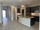 Open concept kitchen with island and access to pantry and entryway at 15963 W Montana De Oro Dr, Surprise, AZ 85387