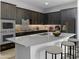 Modern kitchen with dark cabinetry, quartz countertops, and island with seating at 15963 W Montana De Oro Dr, Surprise, AZ 85387