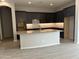 Modern kitchen with island, dark cabinetry, and tile backsplash at 15963 W Montana De Oro Dr, Surprise, AZ 85387