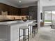 Modern kitchen with dark cabinets, quartz countertops, island, and view to backyard at 15963 W Montana De Oro Dr, Surprise, AZ 85387