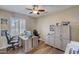 Home office with two desks, wood cabinets, and a large window at 17780 W Canto Bonito Ln, Surprise, AZ 85387