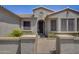 Front entry of a charming home with decorative gate and landscaping at 17780 W Canto Bonito Ln, Surprise, AZ 85387