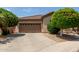 Exterior view of a beige house with a brown garage door and well-manicured landscaping at 2074 E Hulet Pl, Chandler, AZ 85225
